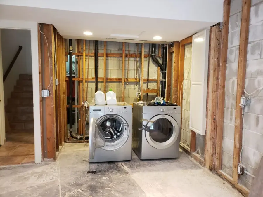 Basement laundry with opened walls after an appliance leak, Loveland, CO