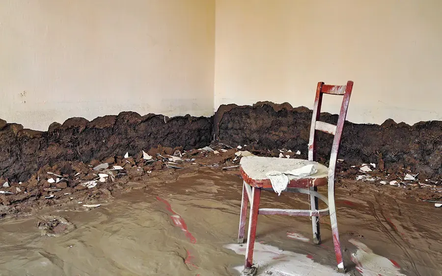 Mud and flood debris against a wall inside a flooded home, flood water cleanup in Loveland, CO