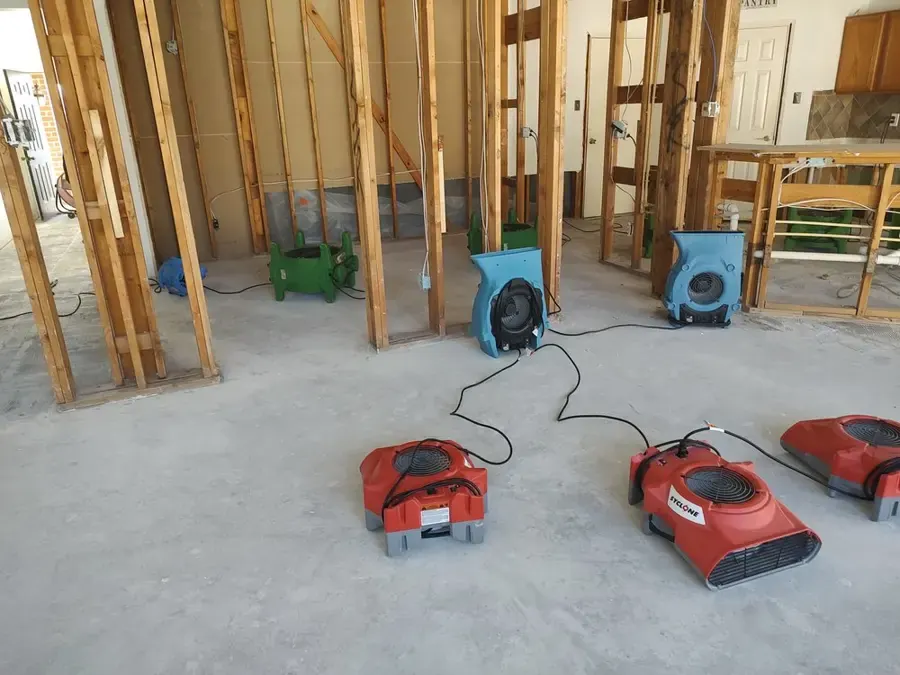 Air movers drying exposed wall studs and a concrete floor, structural drying in Loveland, CO