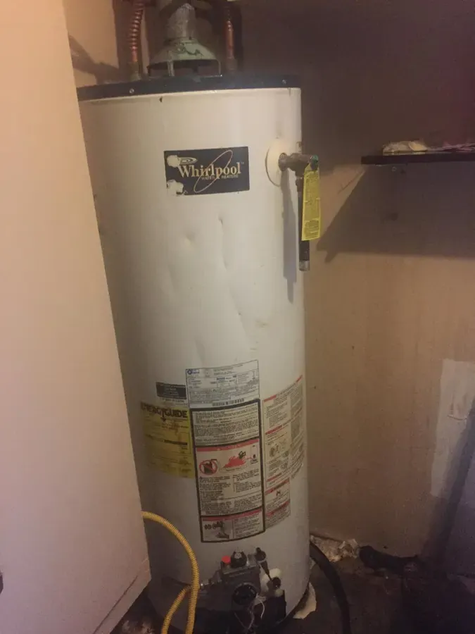 Water heater in a utility closet with water staining around the base, water heater failure in Loveland, CO